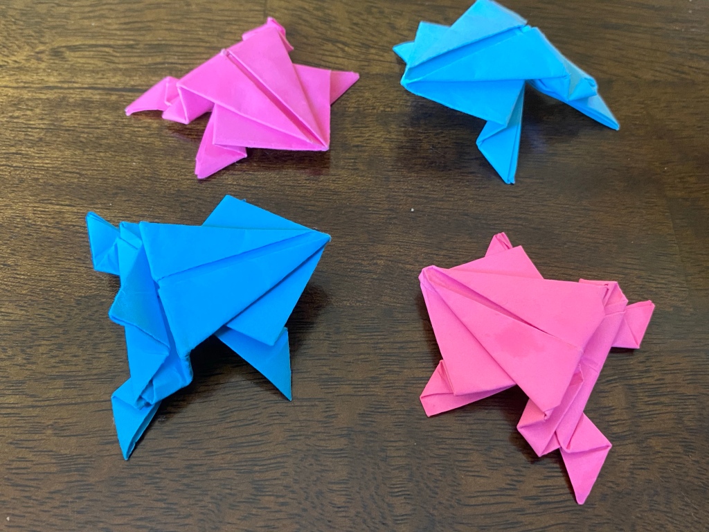 2 pink and 2 blue origami frogs arranged in a circle