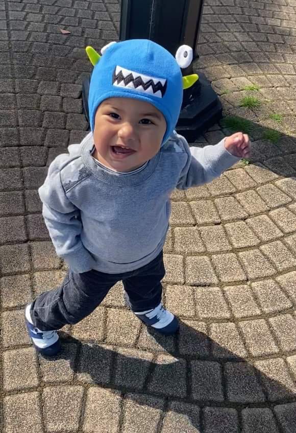 Justice taking a walk outside wearing a blue monster beanie.